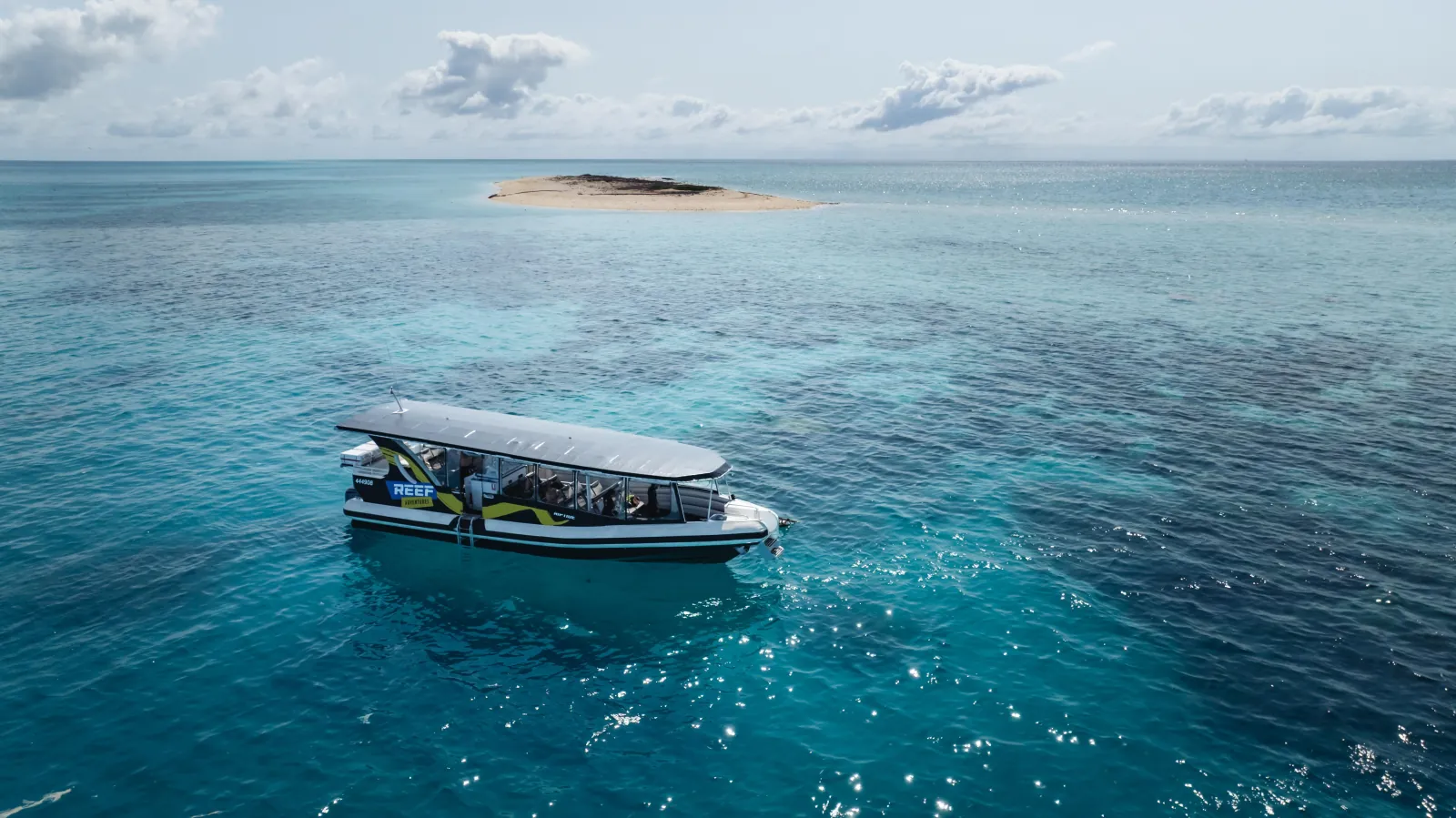 Small reef boat moored near a sand cay