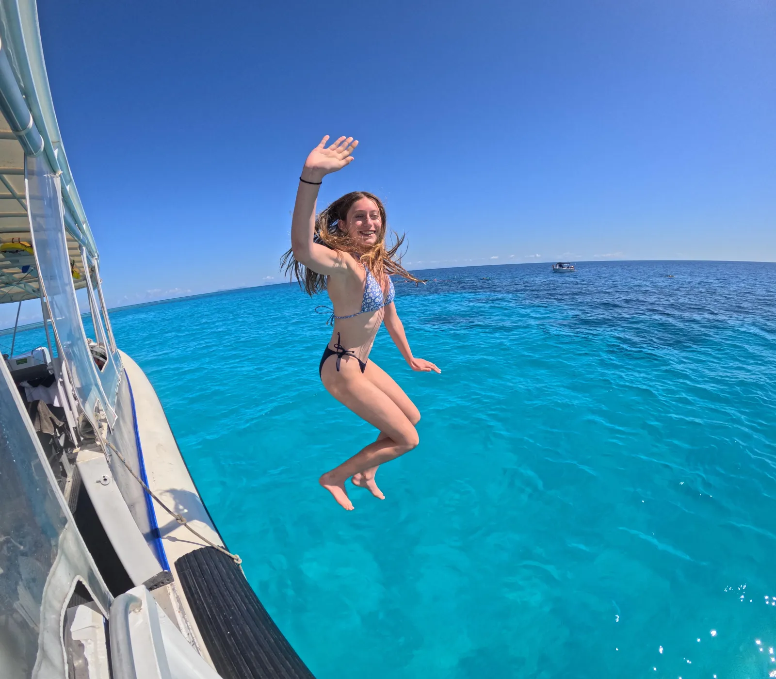 Guest jumping from the boat into turquoise water