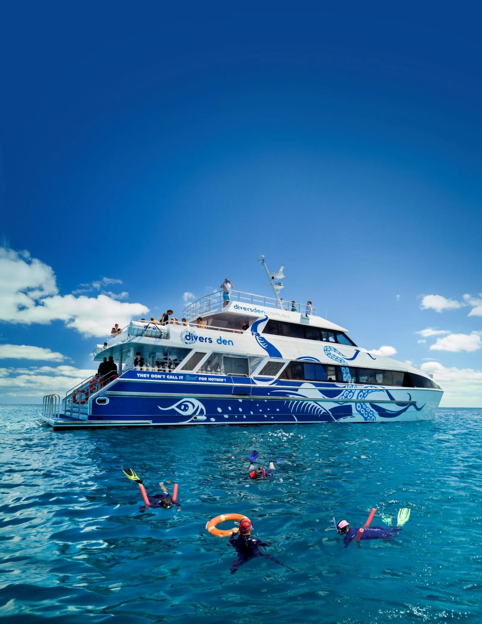 Reef boat moored with snorkellers in the water nearby