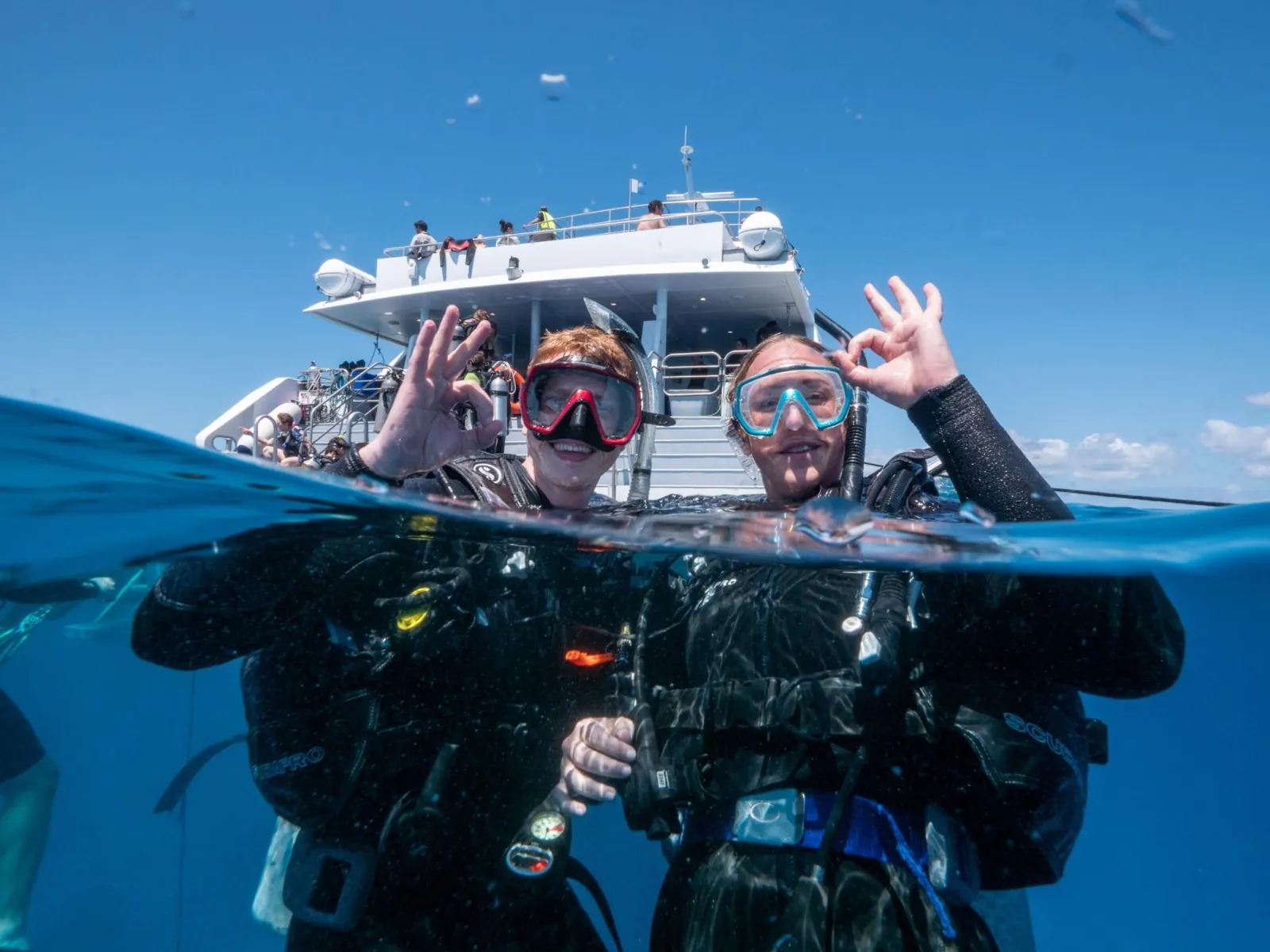 Divers surfacing at the boat stern