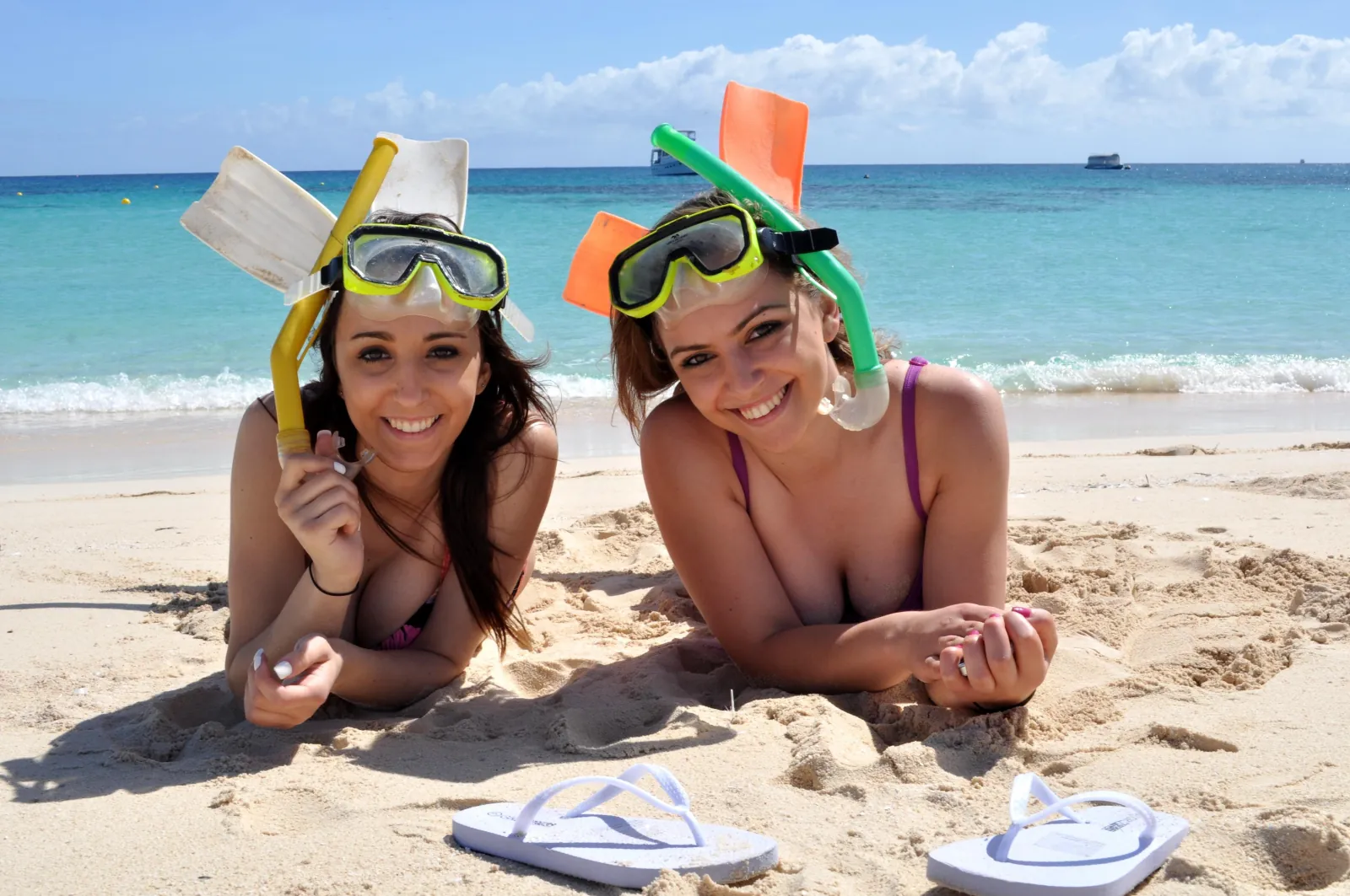 Two snorkellers lying on the sand of the cay