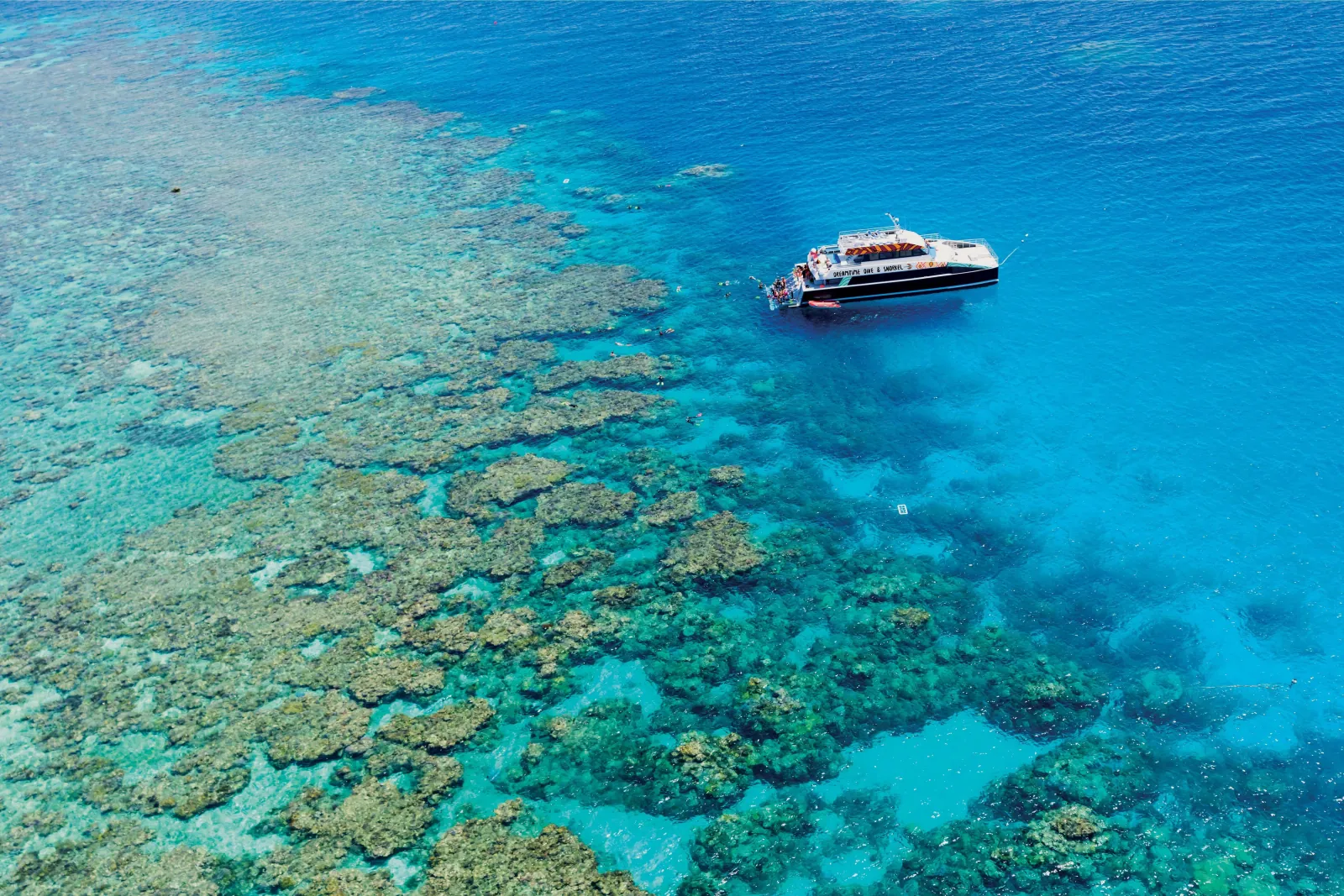 Aerial view of the boat moored over a large reef