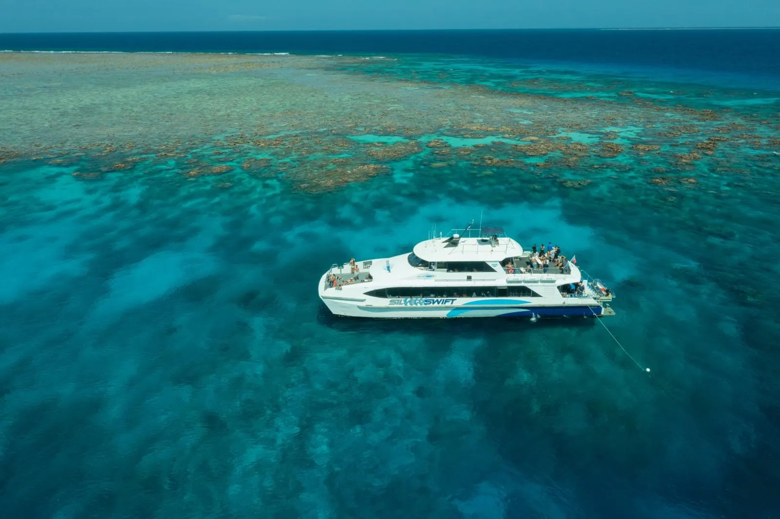 Silverswift catamaran moored over turquoise reef water