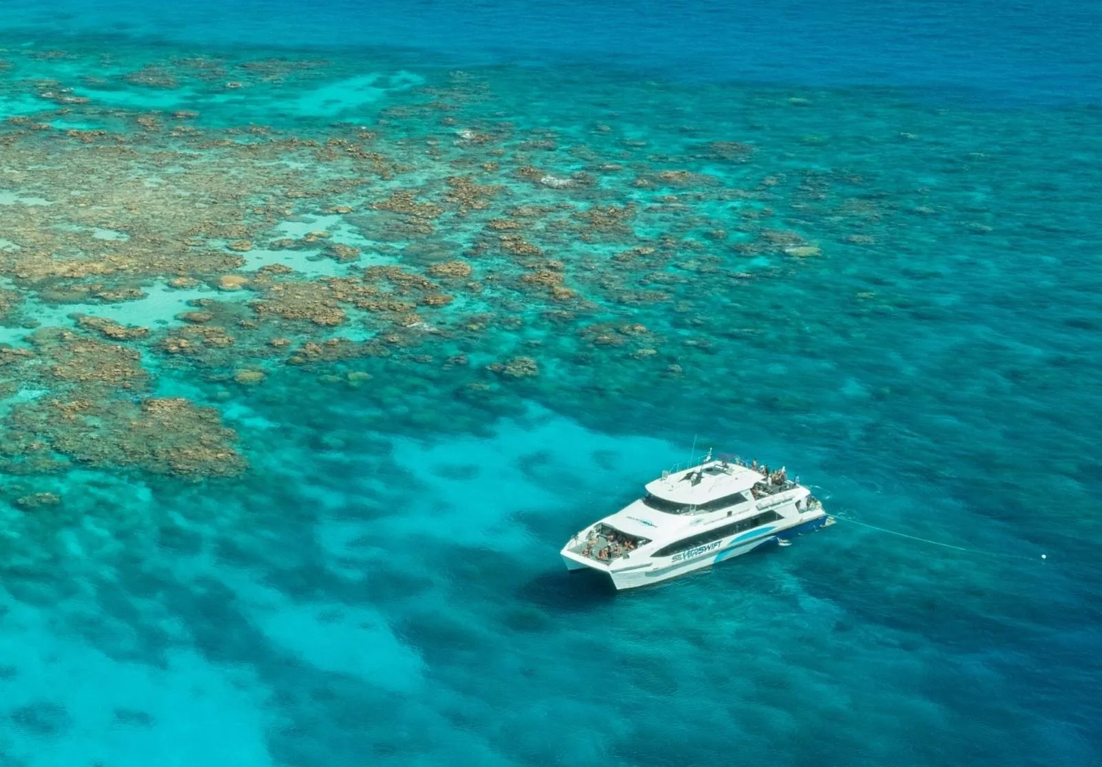 Aerial view of the catamaran beside a reef edge