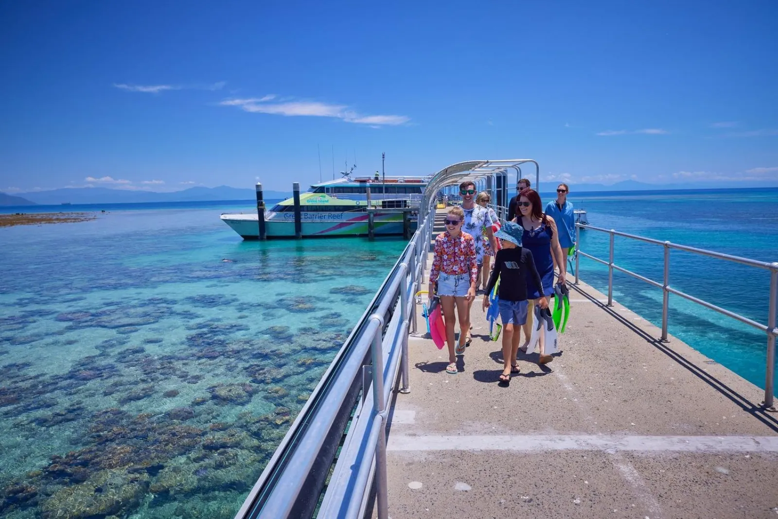 Passengers on the jetty with the catamaran moored behind