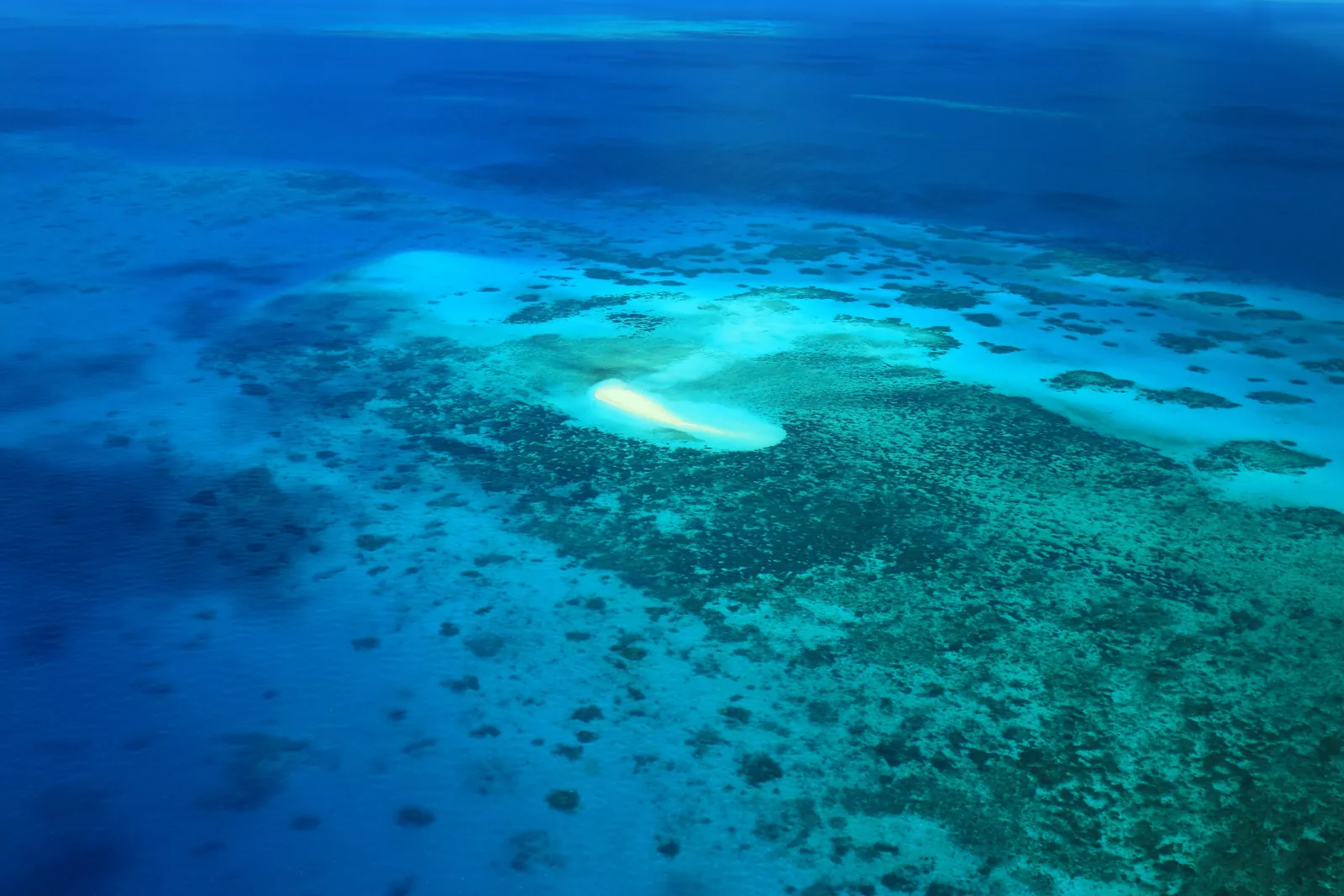Aerial view of a reef lagoon in deep blue water