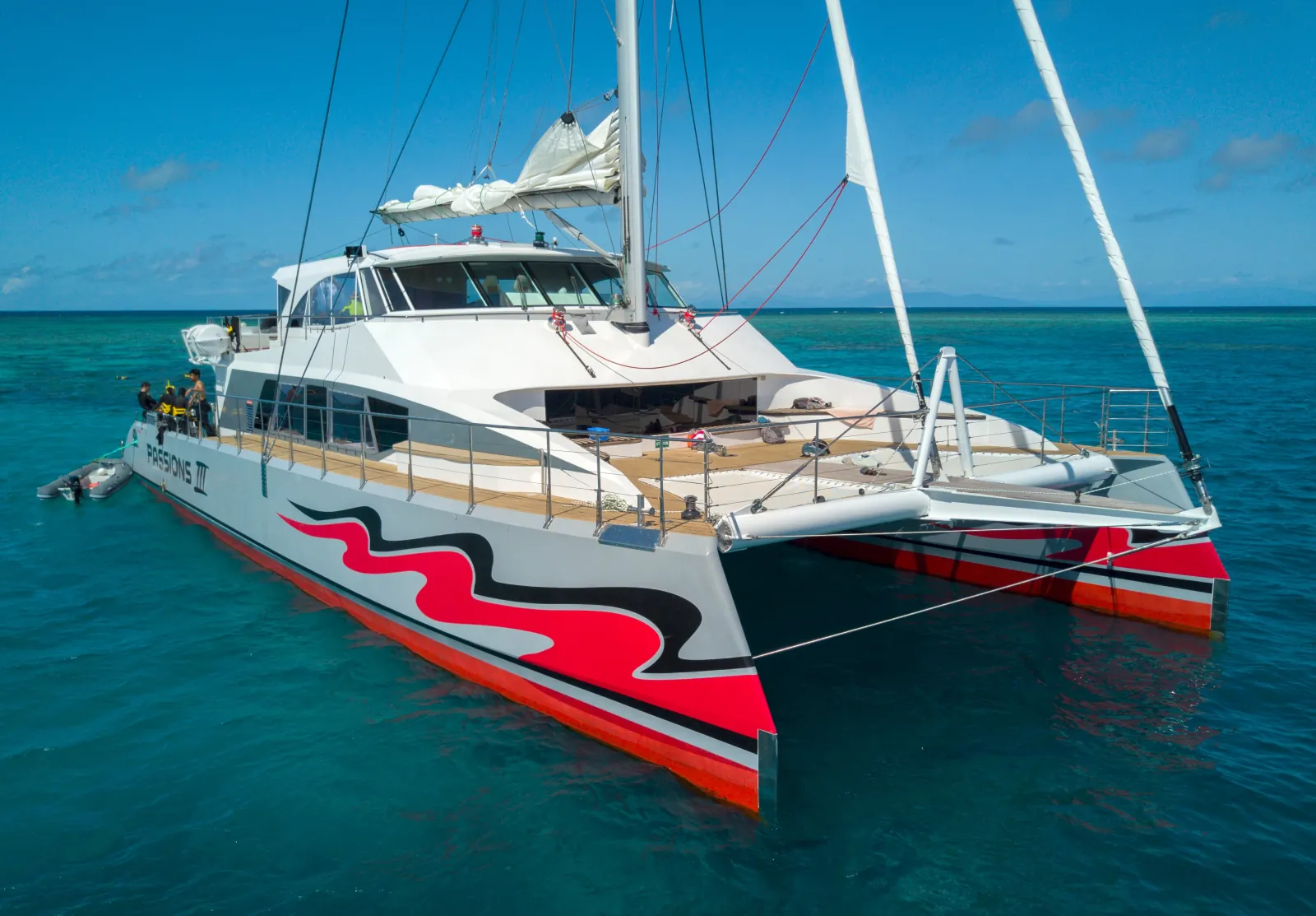 Red and white sailing catamaran moored at the reef