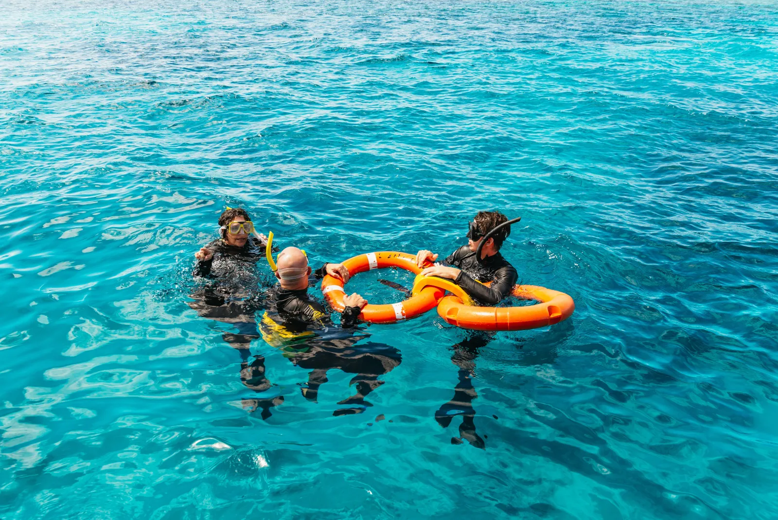 Snorkellers floating together on a ring float over the reef