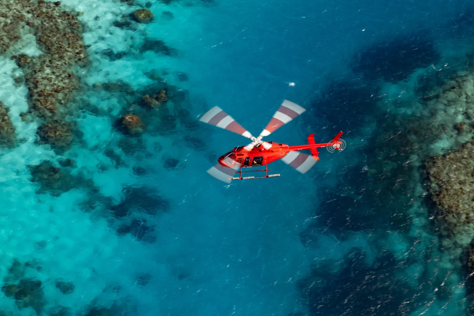 Helicopter above coral heads in clear water