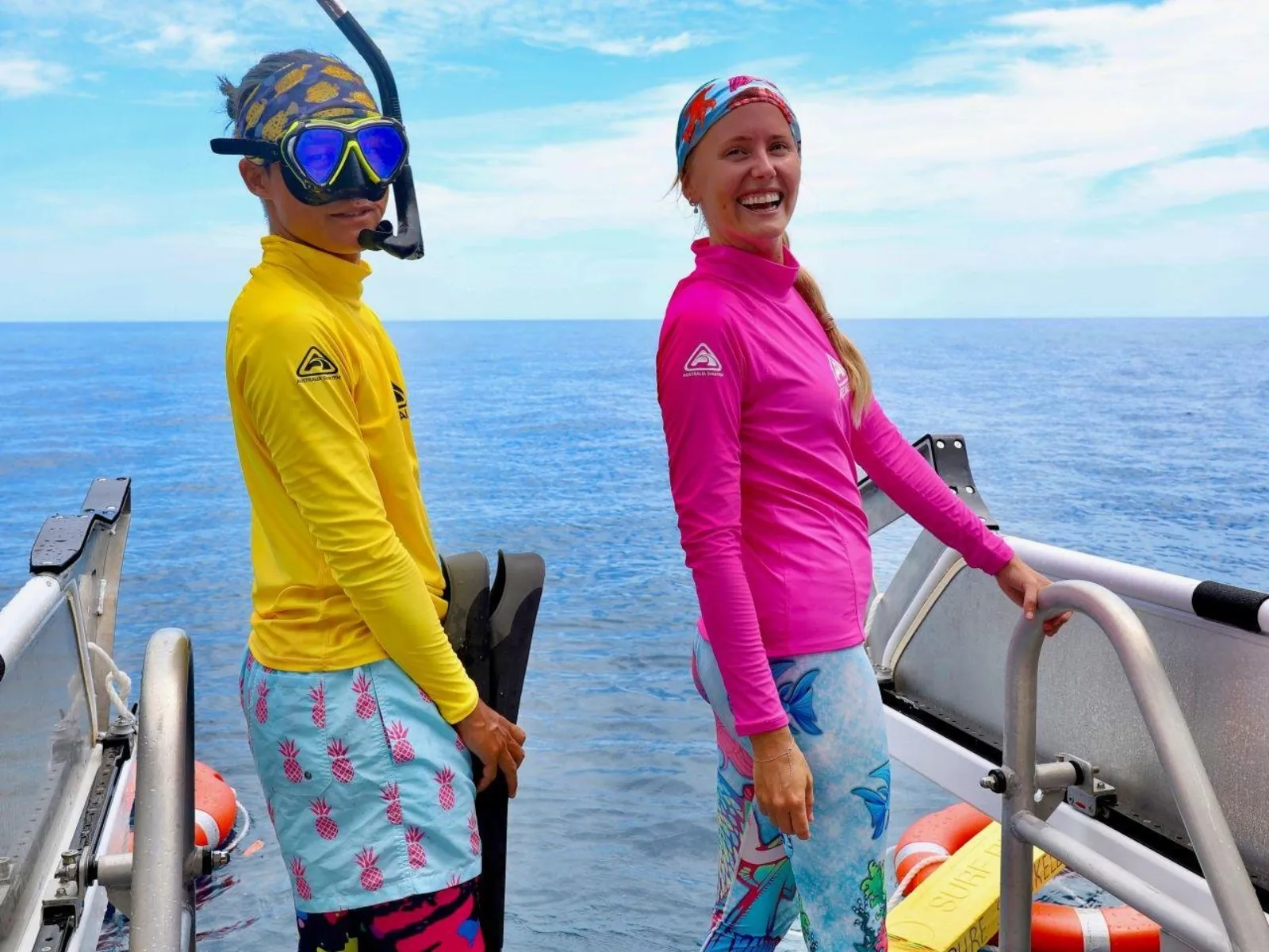 Snorkel guide and guest in stinger suits on deck