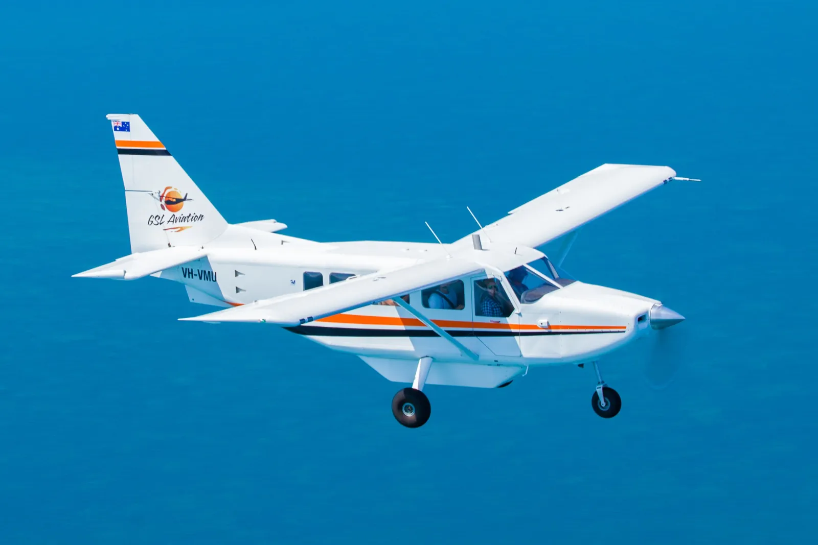 Light aircraft over deep blue water